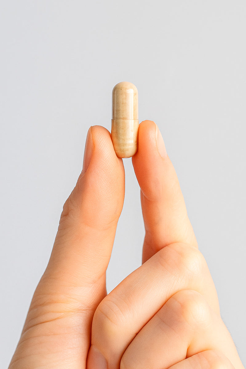 mão com uma capsula na mão